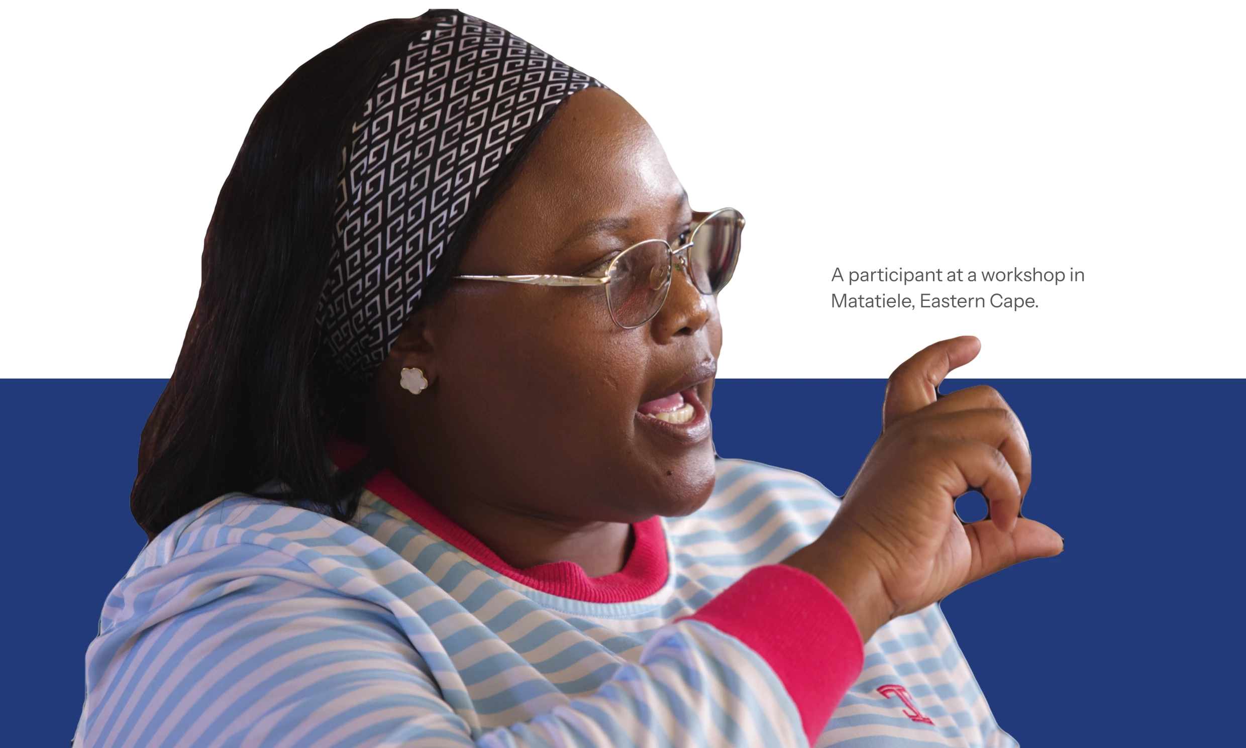 A woman in glasses and a patterned headband speaking and gesturing with one hand.